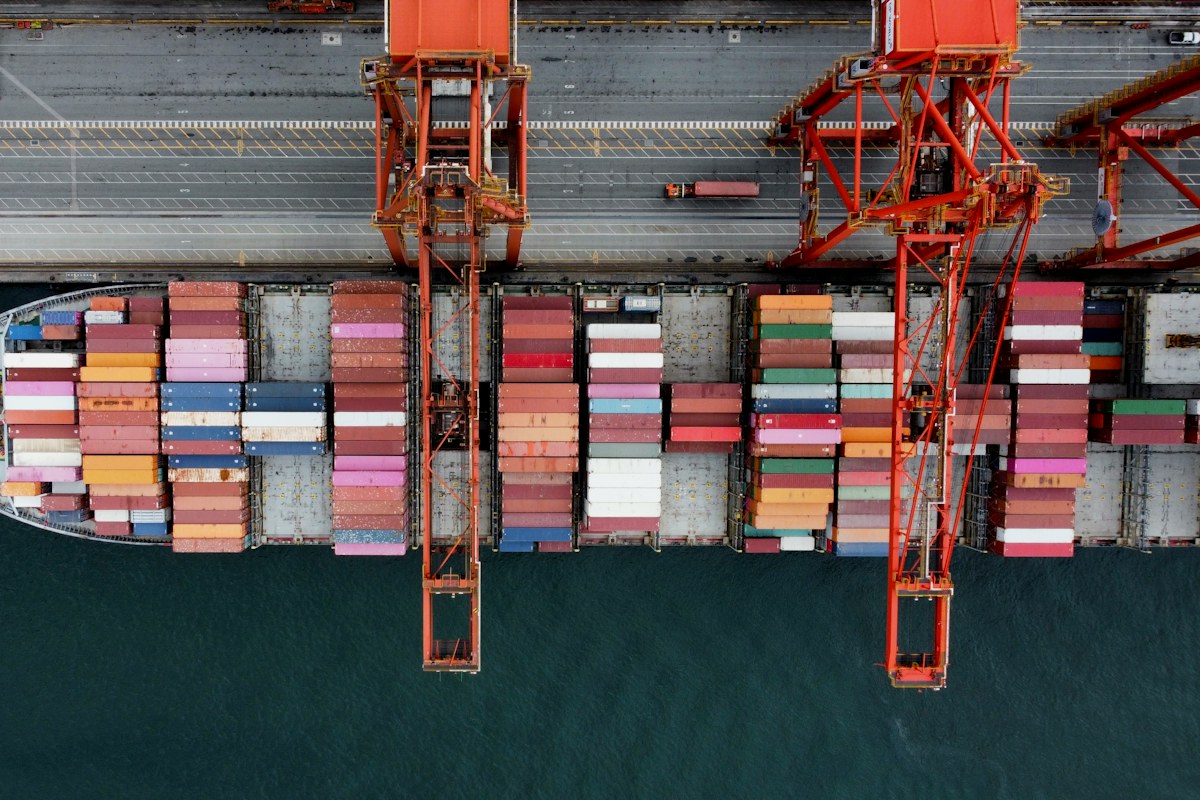 International shipping and container port Aerial view of a container ship being unloaded beside port cranes
